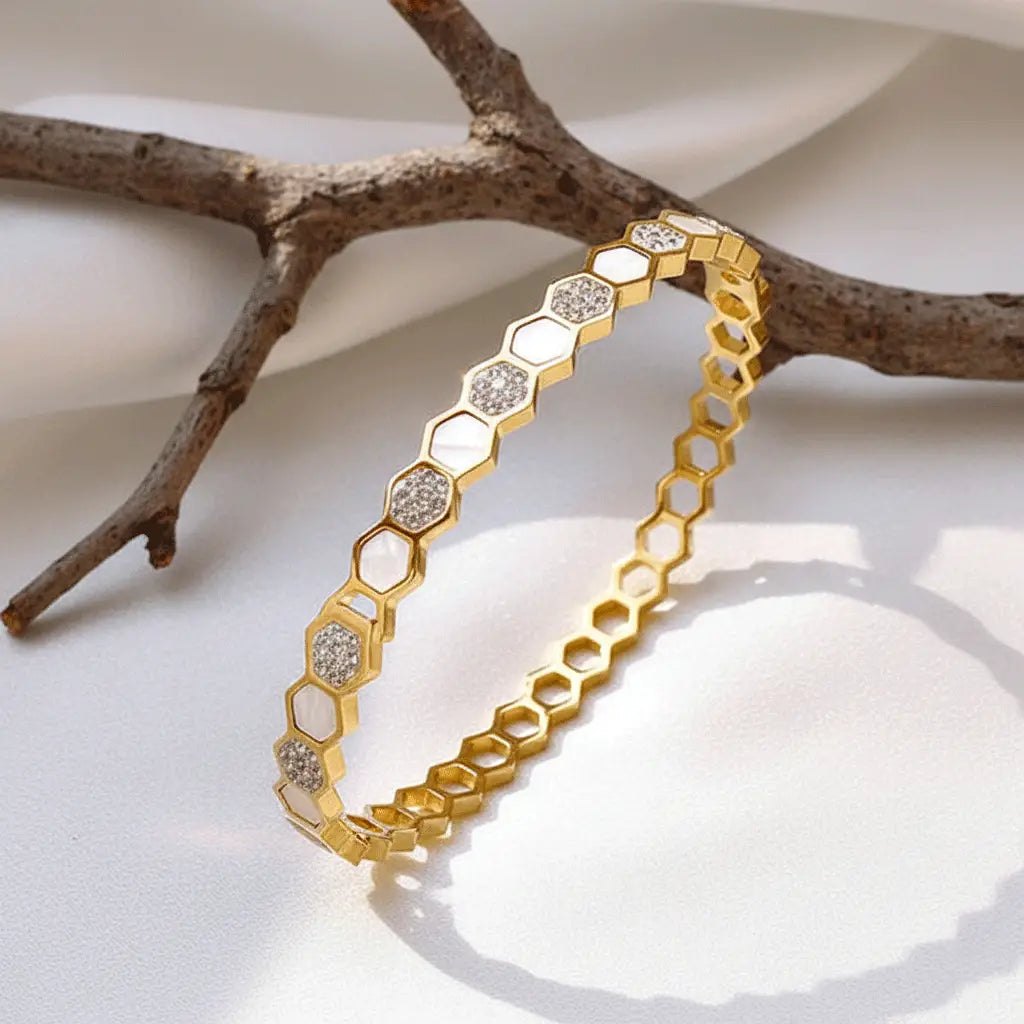 Gold hexa charm bracelet featuring alternating white enamel and diamond-studded segments.