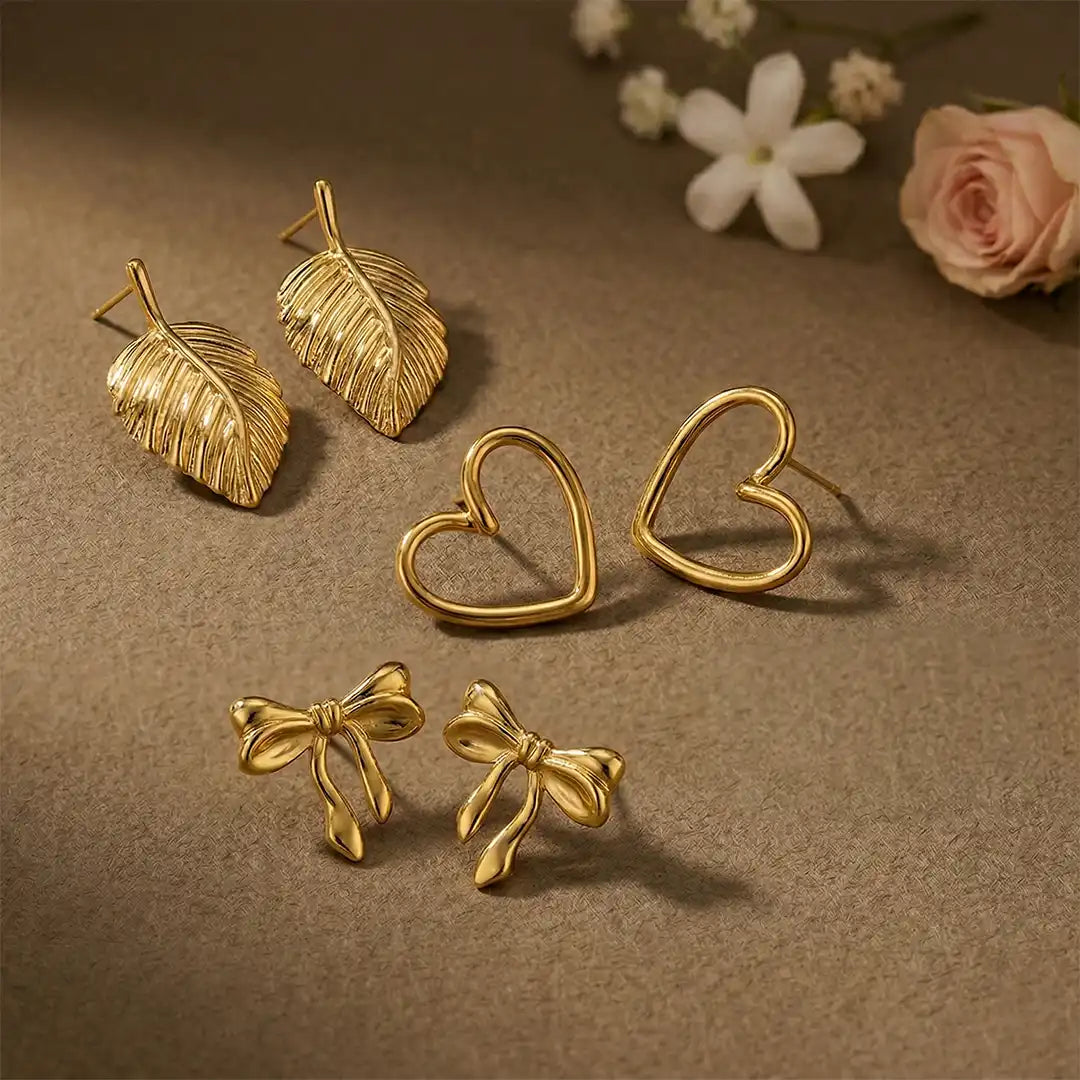 K-A Trends anti tarnish gold earrings combo featuring textured leaf studs, open heart studs and bow knot earrings premium jewellery flatlay