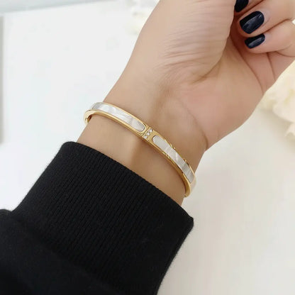 Mother-of-Pearl Gold bracelet featuring elongated mother-of-pearl inlays and a small cluster of crystals.