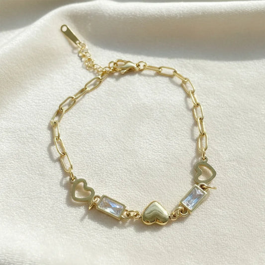 Anti-tarnish heart-link gold bracelet features a stylish chain design with a heart and crystal charms.