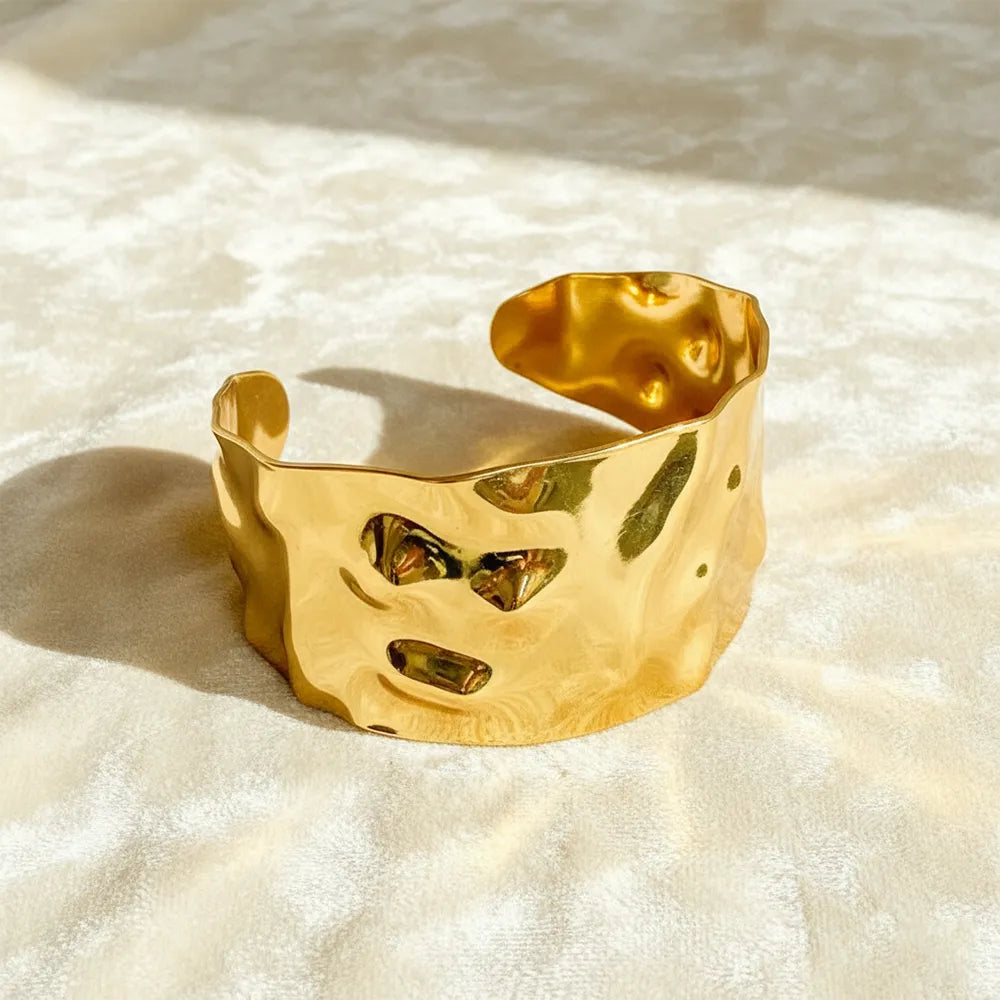 This textured glow bracelet features a hammered gold-plated design with a smooth adjustable fit.