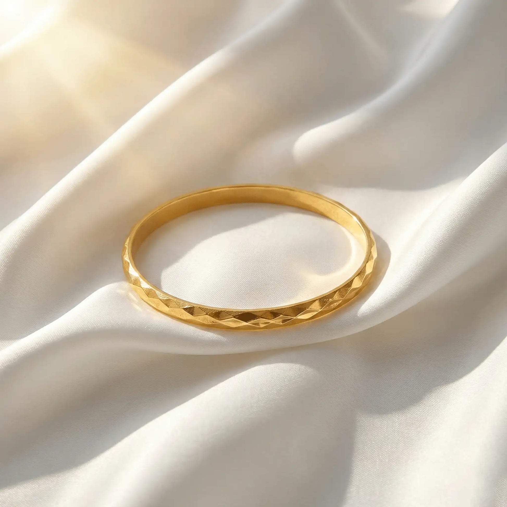 2 Diamond Cut Bangle anti-tarnish gold bangle on white fabric in natural sunlight