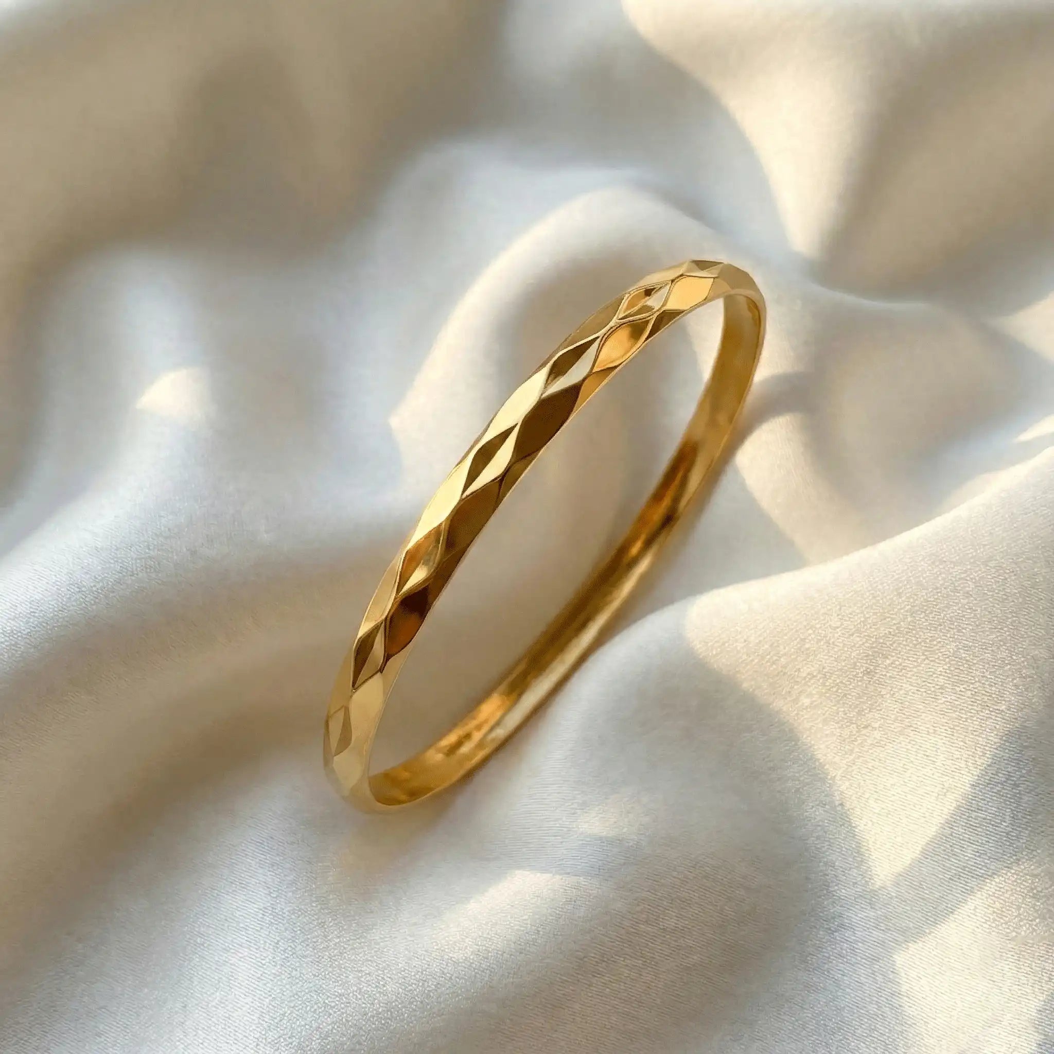 2 Diamond Cut Bangle anti-tarnish gold bangle with diamond-cut texture on satin fabric