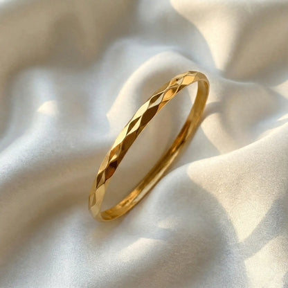 2 Diamond Cut Bangle anti-tarnish gold bangle with diamond-cut texture on satin fabric