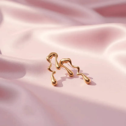 Pair of abstract gold drop earrings designed to make a bold style statement