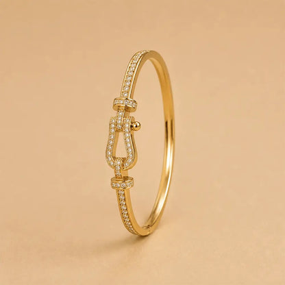 A Belt Buckle Kada adorned with pavé-set clear stones, shown on a warm beige background.