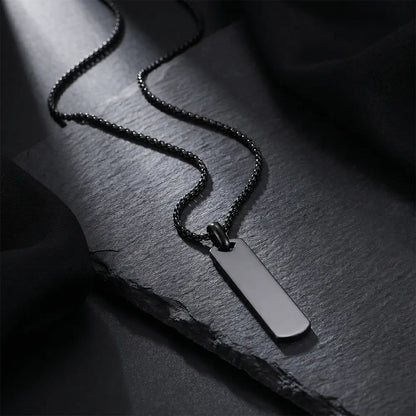 Luxury black stainless steel bar pendant necklace on dark textured background by K-A Trends