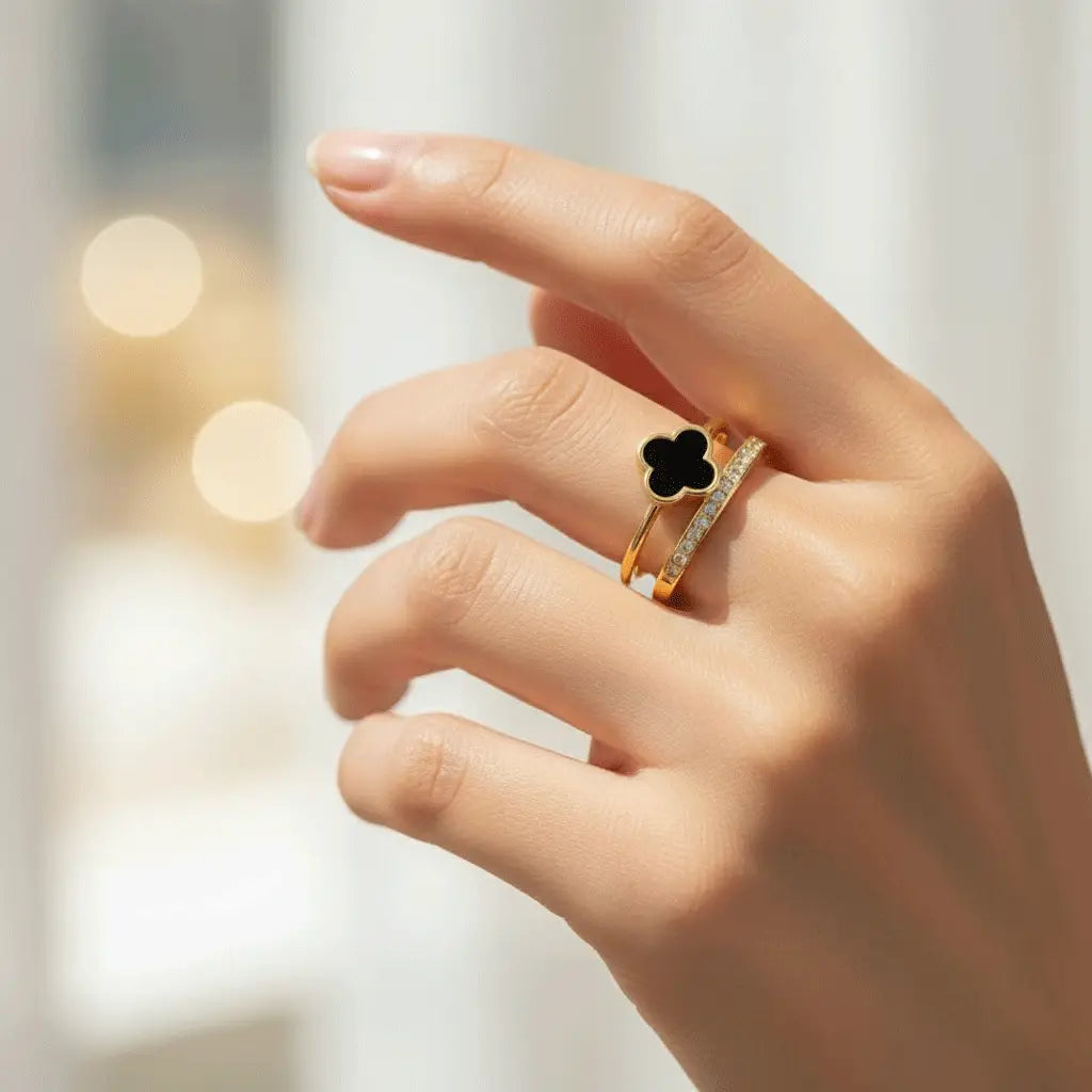 Stylish Black Clover Ring with sparkling crystal band worn on hand in soft indoor lighting.