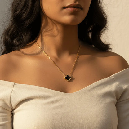 Close-up showing the reversible clover pendant with anti-tarnish finish, highlighting both elegant black and white faces.