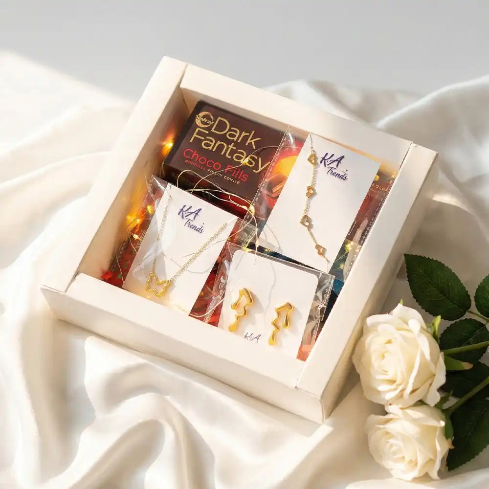 Elegant Butterfly Love anti-tarnish jewellery and chocolate hamper featuring butterfly necklace, statement earrings, Dark Fantasy Choco Fills, and warm fairy lights on a satin background.