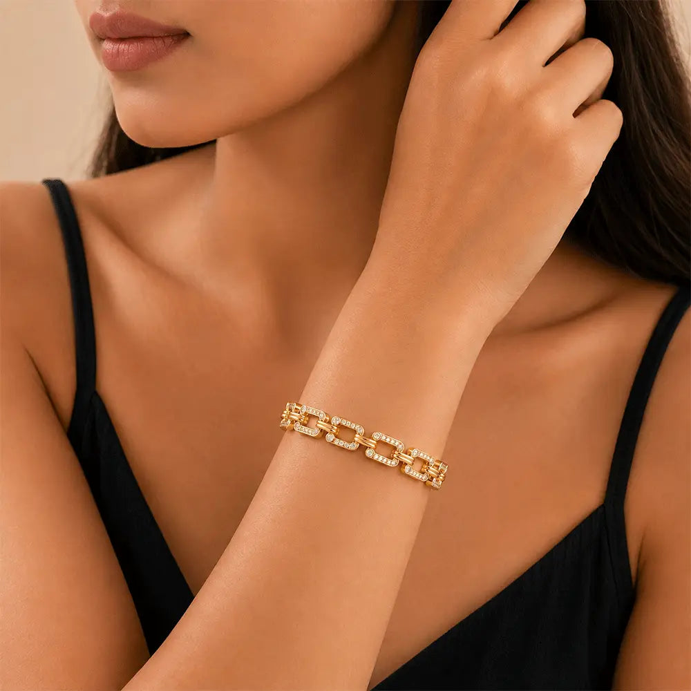 A close-up lifestyle shot of a woman wearing chain link kada adorned with small clear stones, paired with a black spaghetti-strap top.