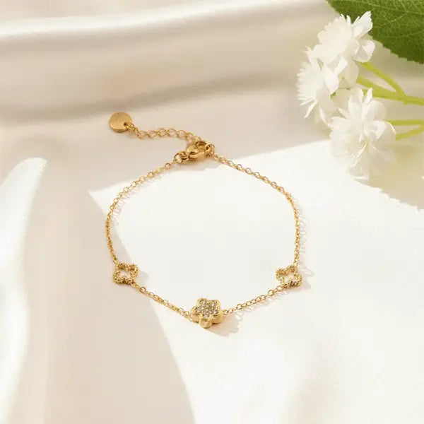 Charm Link Bracelet with adjustable chain clasp, gold plated floral charm bracelet on white satin background
