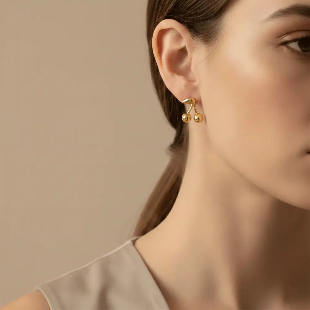 Model wearing cherry drop stud earrings in gold finish, anti tarnish minimalist earrings for women by K-A Trends