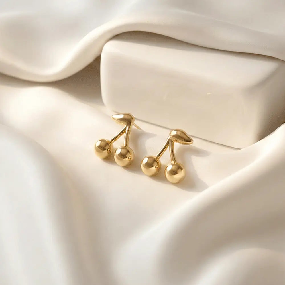 Cherry drop stud earrings on soft white satin background, glossy gold anti tarnish earrings by K-A Trends