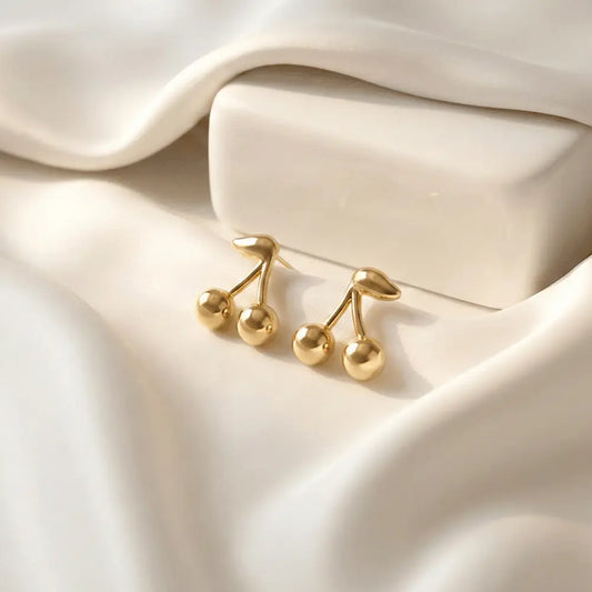 Cherry drop stud earrings on soft white satin background, glossy gold anti tarnish earrings by K-A Trends