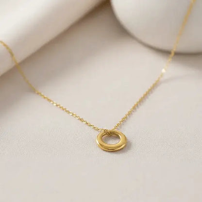 Classic Circle Pendant Necklace – minimal gold round charm on delicate chain displayed on beige background