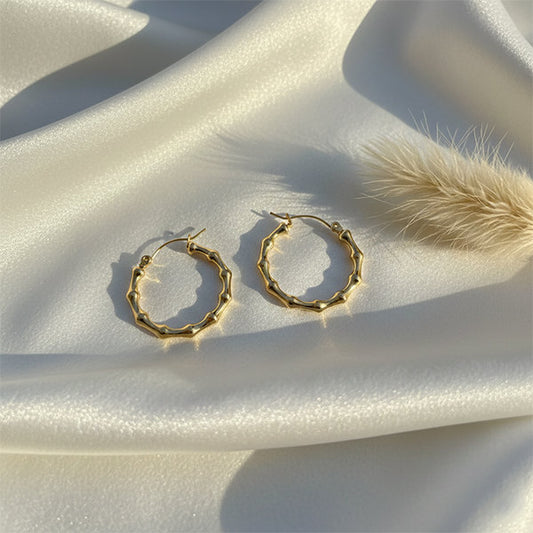 Gold ripple hoop earrings flat lay with pampas grass – anti-tarnish jewellery for everyday wear