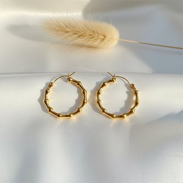 Gold ripple hoop earrings with textured design on satin background – lightweight anti-tarnish hoops