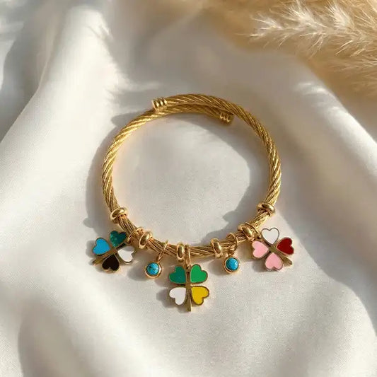 Woman wearing anti-tarnish gold clover charm bangle bracelet with colorful enamel charms