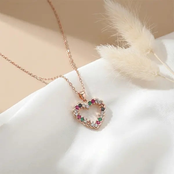 Colorful Love Pendant heart necklace on white satin fabric with soft sunlight and dried white pampas grass