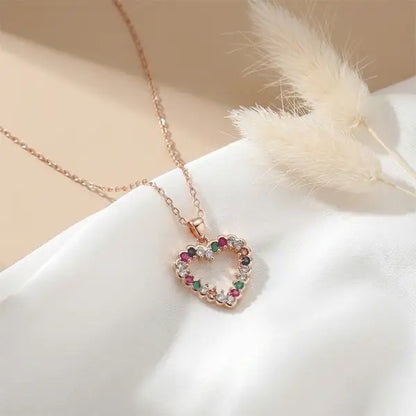 Colorful Love Pendant heart necklace on white satin fabric with soft sunlight and dried white pampas grass