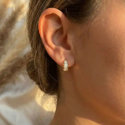 Crystal Curve anti-tarnish gold stud earrings worn on ear in natural sunlight