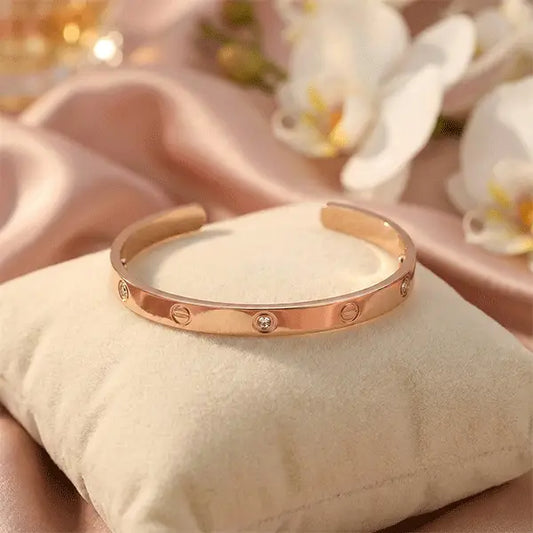 Crystal rose gold bracelet with embedded stones, anti-tarnish open cuff design displayed on a soft cushion