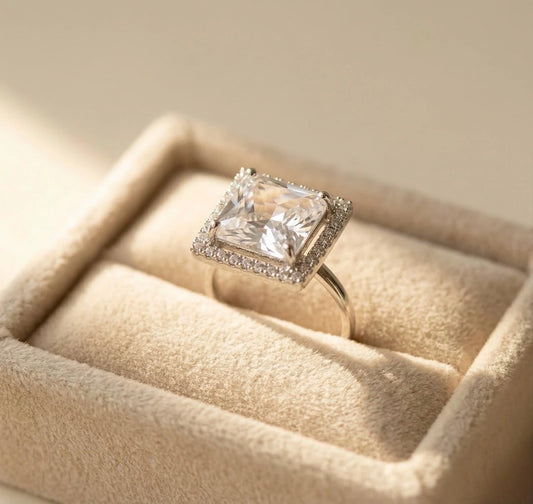Square crystal AD adjustable ring placed in a beige velvet jewellery tray, silver band with halo stones, elegant anti-tarnish statement ring
