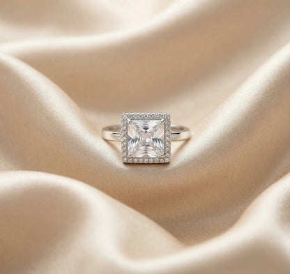 Square crystal AD adjustable ring placed in a beige velvet jewellery tray, silver band with halo stones, elegant anti-tarnish statement ring.