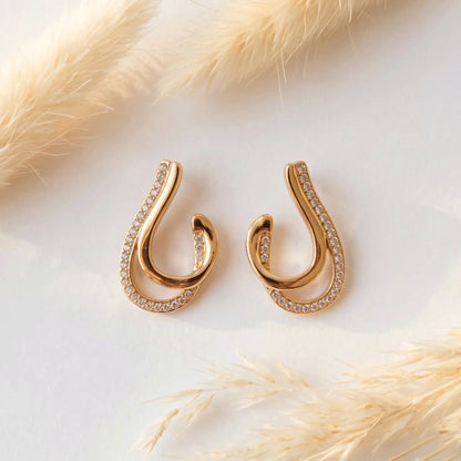 Crystal Curve Drop Earrings with embedded stones on a light background