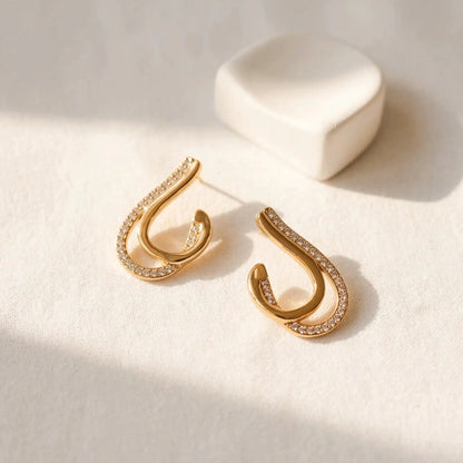 Crystal Curve Drop Earrings with embedded stones on a light background