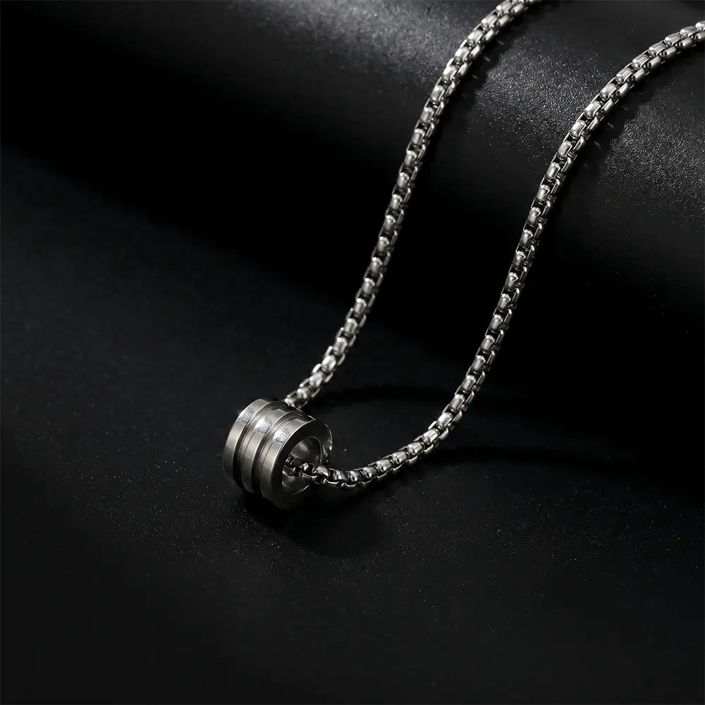 Modern men’s silver cylinder pendant necklace with stainless steel chain on black luxury background by K-A Trends