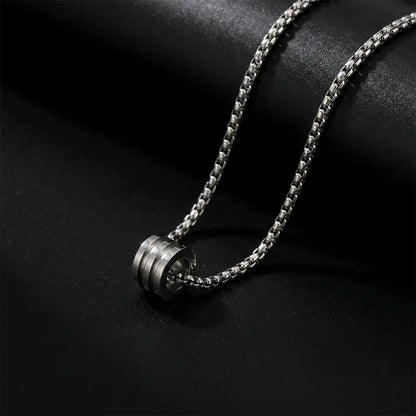 Modern men’s silver cylinder pendant necklace with stainless steel chain on black luxury background by K-A Trends