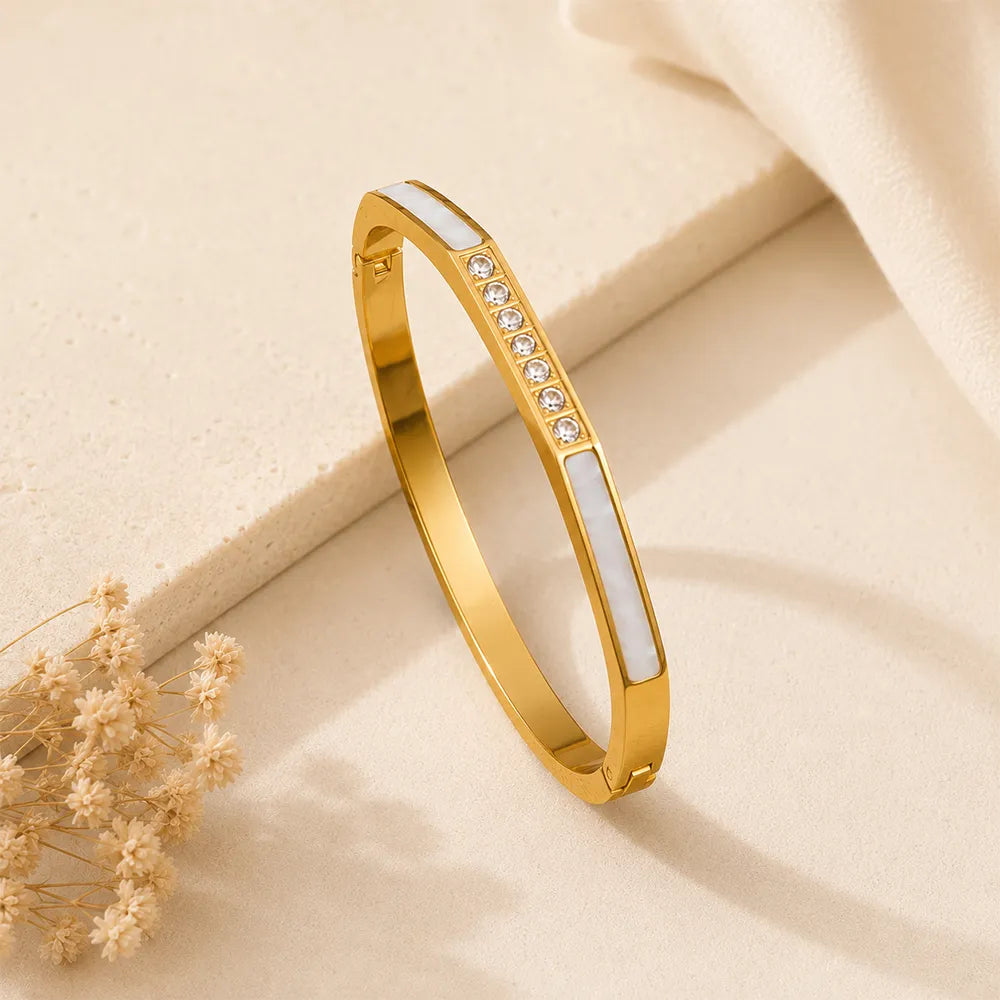 Diamond Edge anti tarnish brass bracelet featuring white inlay panels and a row of sparkling crystals on a gold-toned finish.