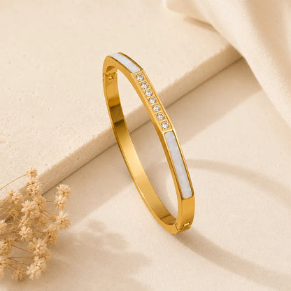 Diamond Edge anti tarnish brass bracelet featuring white inlay panels and a row of sparkling crystals on a gold-toned finish.