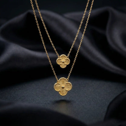 Double gold clover pendant necklace with layered design, anti-tarnish finish, luxury jewellery on black fabric background