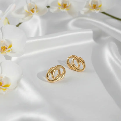 K-A Trends anti tarnish gold double loop stud earrings on white silk fabric with orchid flowers luxury product shoot