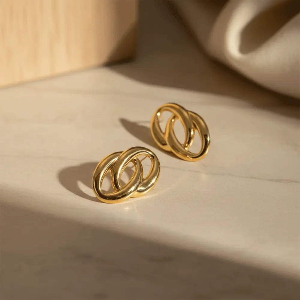 K-A Trends anti tarnish gold double loop stud earrings on beige surface with natural sunlight shadow premium jewellery