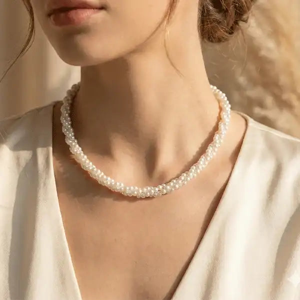 Single strand pearl necklace worn on model neck in soft natural light