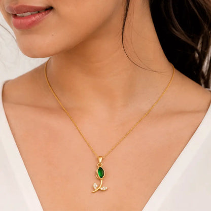 Indian model wearing Emerald Petal anti tarnish pendant necklace with an emerald green gemstone and sparkling leaf-inspired design.