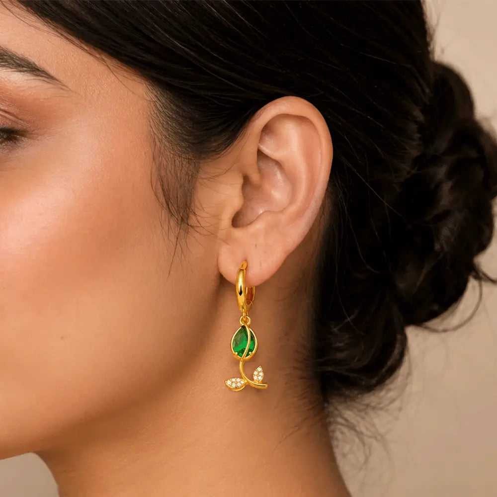 Indian model wearing Emerald Petal anti tarnish hoop earrings featuring green marquise stones and crystal leaf details.