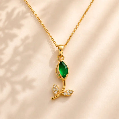 Close-up of Emerald Petal anti tarnish pendant necklace featuring a green marquise gemstone and sparkling crystal leaf accents on a gold-toned chain.