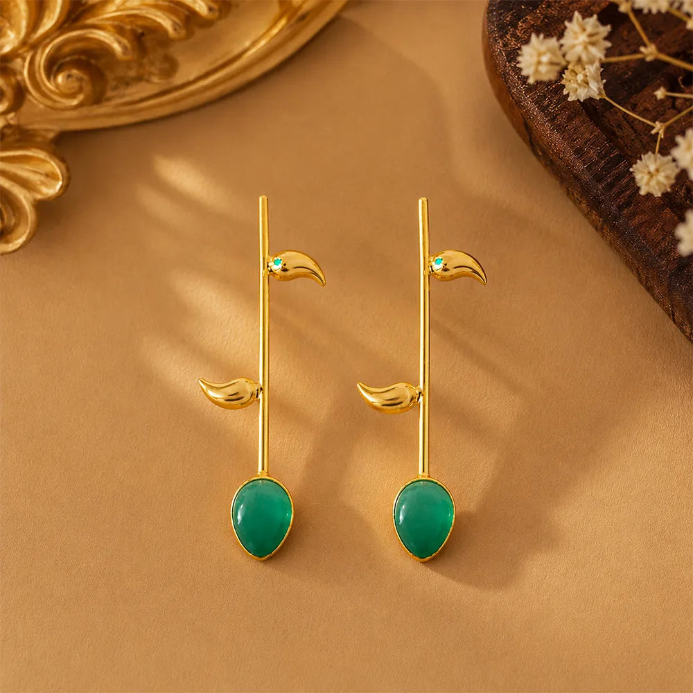 Angled view of Emerald Vine anti tarnish brass earrings featuring glossy green stones and elegant botanical-inspired gold detailing.