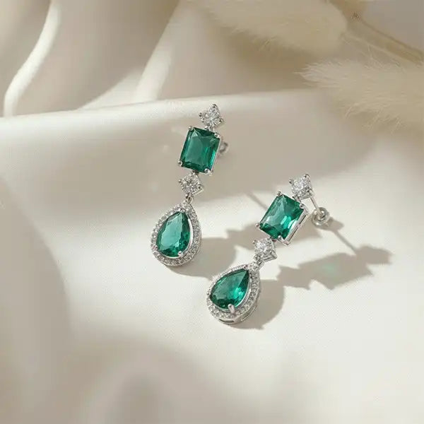 Evergreen Royale Necklace Set emerald green drop earrings on satin cloth with soft sunlight