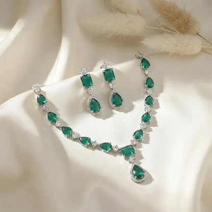 Evergreen Royale Necklace Set displayed on satin cloth with pampas grass, emerald green jewellery set