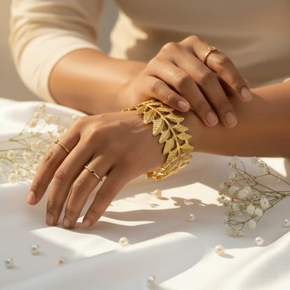 The adjustable Golden Leaf Cuff Bracelet with detailed leaf patterns and a premium gold finish adds a stylish touch to both traditional and western outfits. 