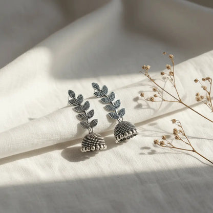 Silver oxidised Pankhuri Jhumka earrings featuring leaf motifs and textured dome hangings.