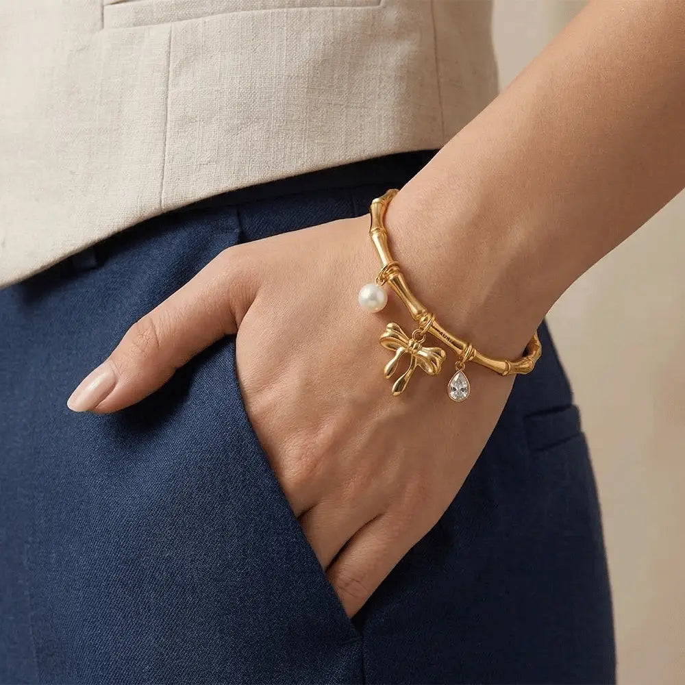 Woman wearing gold charm kada bracelet with pearl and crystal pendant, stylish anti-tarnish bracelet for everyday wear