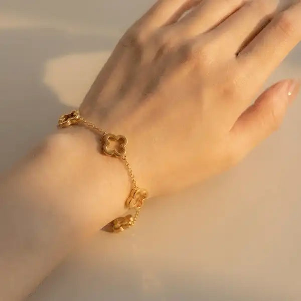 Woman wearing gold clover bracelet on wrist, lightweight anti-tarnish everyday jewellery