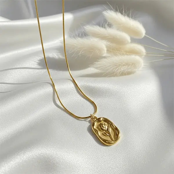 Gold Serenity Pendant necklace on white satin fabric with soft sunlight and dried pampas grass – minimal luxury jewellery